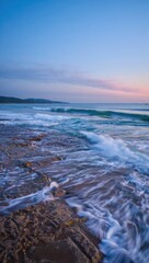 Obraz premium Serene coastal dawn waves crashing on rocks