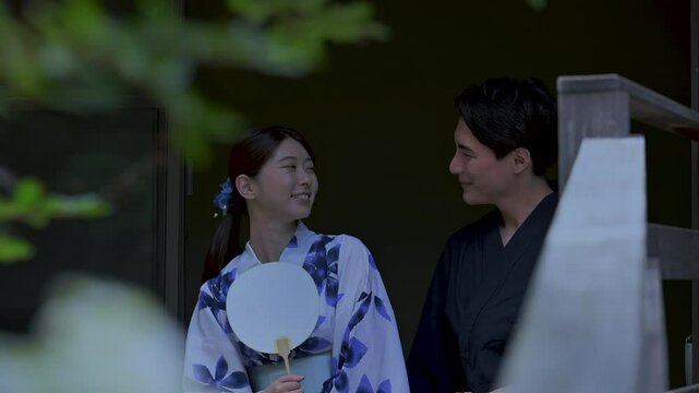 夫婦やカップルでの浴衣で縁側で座る　夜の花火を見る動画 花火の反射と音付き