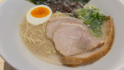 Authentic Tonkotsu Ramen with Chashu Pork, Soft-Boiled Egg, and Scallions in White Bowl