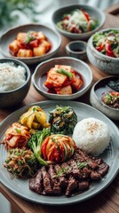 A beautiful Korean dinner spread with bulgogi, kimchi, japchae, banchan (side dishes), steamed rice. Sleek modern Korean interior. Elegant and clean composition