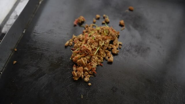 Spiced chicken shawarma filling with herbs being cooked on a flat griddle surface. Pakistan