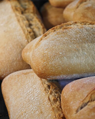 Freshly baked artisan bread loaves cooling on a wooden surface in a cozy bakery