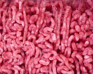 Obraz premium Freshly ground minced meat ready for cooking in a kitchen setting during the daytime