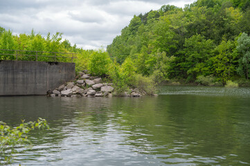 Obraz premium Selective focus background image of Quaker Lake NY, Dam spillway spring bloom foliage, outdoors backgrounds