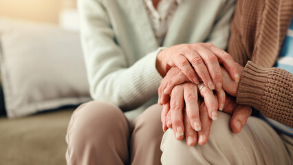 Holding hands, closeup and senior couple on sofa for comfort, empathy and support together....
