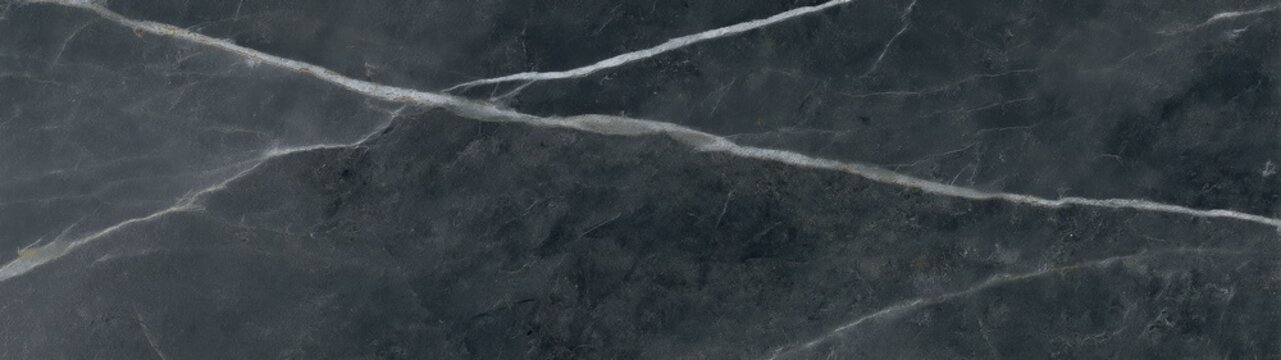 Honed soapstone surface with white veins crossing dark gray natural mineral texture