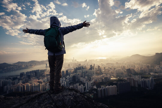 Successful backpacker enjoy the view stand on the cliff edge in hong kong