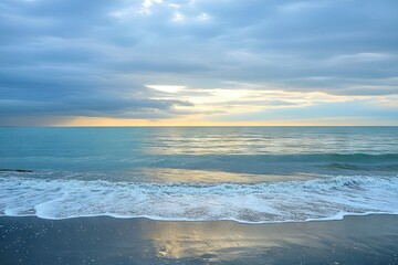 Fototapeta premium Calm ocean sunrise, soft waves on a beach