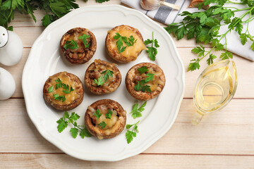 Tasty stuffed mushrooms served on wooden table, flat lay
