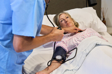 Obraz premium Caregiver assisting elderly patient in rehabilitation facility monitoring health