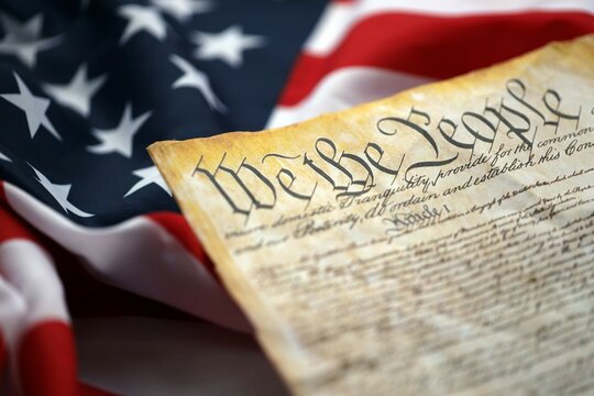 Preamble to the Constitution of the United States and American Flag close up - Powered by Adobe