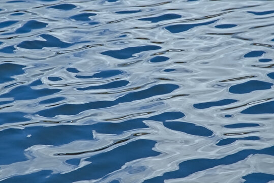 dark blue rippling water surface with light reflections background  - Powered by Adobe