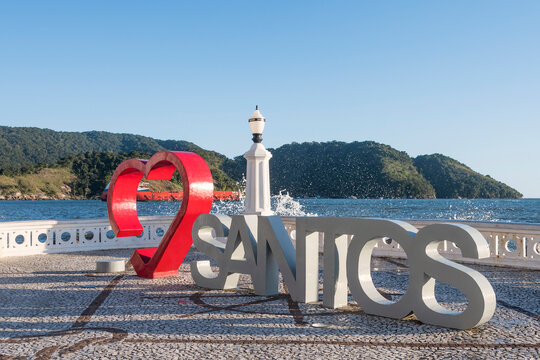 Santos, Brazil. I love the city of Santos. Red heart. Tourist attraction for taking photos by the sea, including the old lamppost and the city wall. Ship entering the harbor channel.
