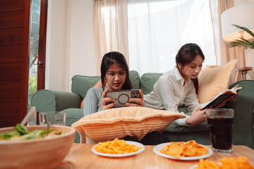 Asian Woman Friend Doing Lifestyle Indoor Smiling Phone Happiness, Sharing Joy and Memories Together at Home, Relaxing on Sofa with Smart Devices and Family Bonding Moments