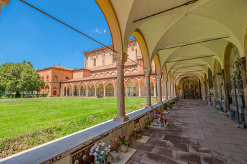 Ferrara, Italy - May 17, 2025: Cemetery of the Charterhouse of Ferrara with its characteristic arcades and tombs under a beautiful summer sky with lush green lawn