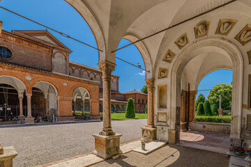 Ferrara, Italy - May 17, 2025: Wide angle view of the entrance to the Ferrara Charterhouse, showing the terracotta arch, decorations, and the hallway with arches and domes, in Ferrara, Italy