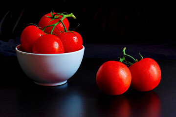 Solanum lycopersicum, commonly known as tomatoes closeup against a black backdrop
