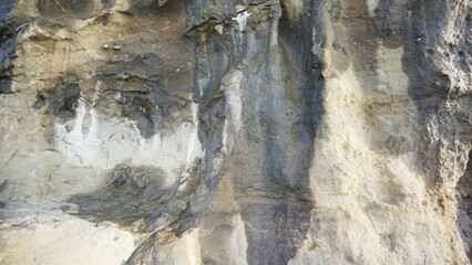 large rock with natural carvings on a cliff near the beach