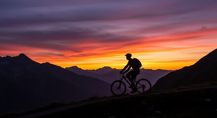 Obraz premium Silhouette of a cyclist riding along a scenic mountain trail during golden sunset, symbolizing freedom and movement.