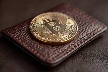 Golden Bitcoin rests on brown leather wallet, showcasing digital currency security and luxury Concept symbolizes financial investment, cryptocurrency, wealth