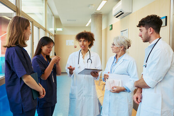 Fototapeta premium Medical team discussing patient status in hospital corridor