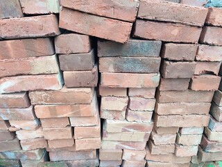 Fototapeta premium pile of bricks for construction, red brick made of clay