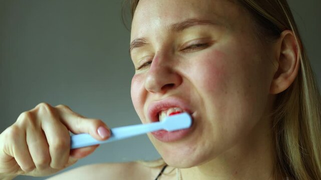 A person is vigorously brushing their teeth in a close-up setting. The expression shows focus and determination, highlighting the importance of dental hygiene in daily routine.