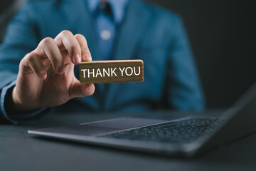 Businessman using a laptop show a text thank you from the laptop. Concept of thank you in business,...