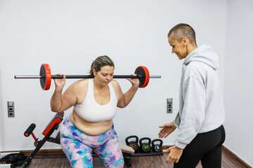 Personal trainer guiding client during weightlifting squat exercise