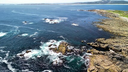 A Stunning Aerial View of the Rocky Coastal Waters and Waves in Natures Splendor