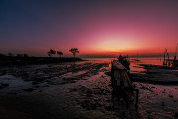 The natural background of the morning light by the sea, the local fishing pier in Ban Tha Sala, Nakhon Si Thammarat, has the beauty of the golden light of the sun.