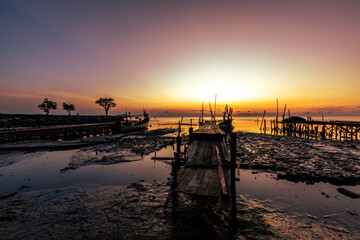 The natural background of the morning light by the sea, the local fishing pier in Ban Tha Sala, Nakhon Si Thammarat, has the beauty of the golden light of the sun.