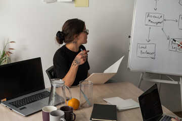 Three software developers brainstorming in a modern office. Team coding session with laptops...