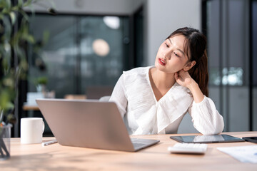 Stressed business woman working from on laptop looking worried, tired and overwhelmed