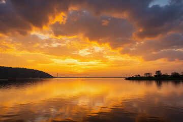 beautiful sunset over a body of water with a bridge in the background