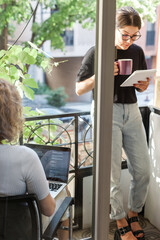 Three software developers brainstorming in a modern office. Team coding session with laptops...