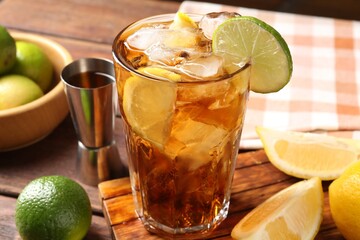 Refreshing Cuba libre cocktail and ingredients on wooden table, closeup