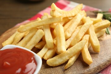Tasty french fries with ketchup on wooden table