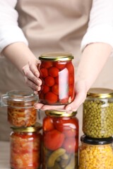 Woman with many jars of different pickled products, closeup