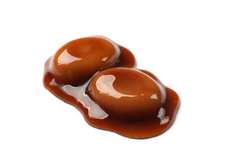 Tasty sweet candies and caramel sauce isolated on white