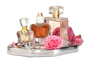Many different perfume bottles and roses isolated on white