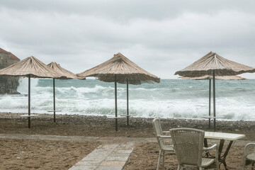 Beach umbrellas on an empty beach by a stormy sea