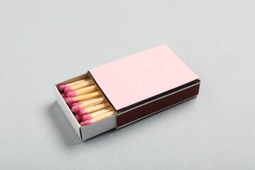 Matches in box on grey background, closeup. Mockup for design