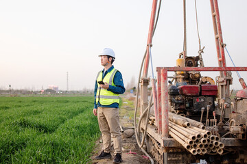 Fototapeta premium asian male engineer using smart phone in construction site