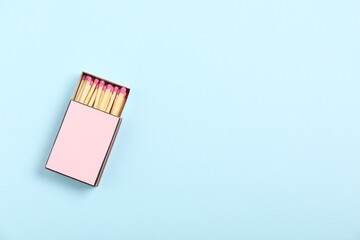 Matches in box on light blue background, top view. Mockup for design