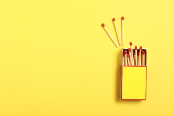 Matches and box on yellow background, flat lay. Mockup for design