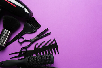 Different hairdresser's tools on violet background, flat lay. Space for text