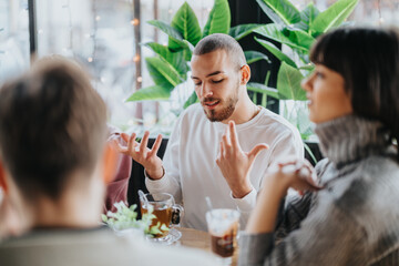 A group of young adults engaged in a vibrant discussion, sitting at a cafe table.