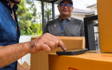 Homeowner man signing to pick up box from delivery man 