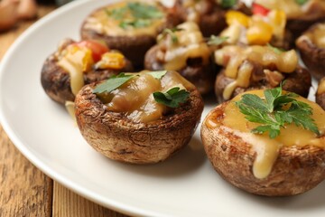 Tasty stuffed mushrooms on wooden table, closeup